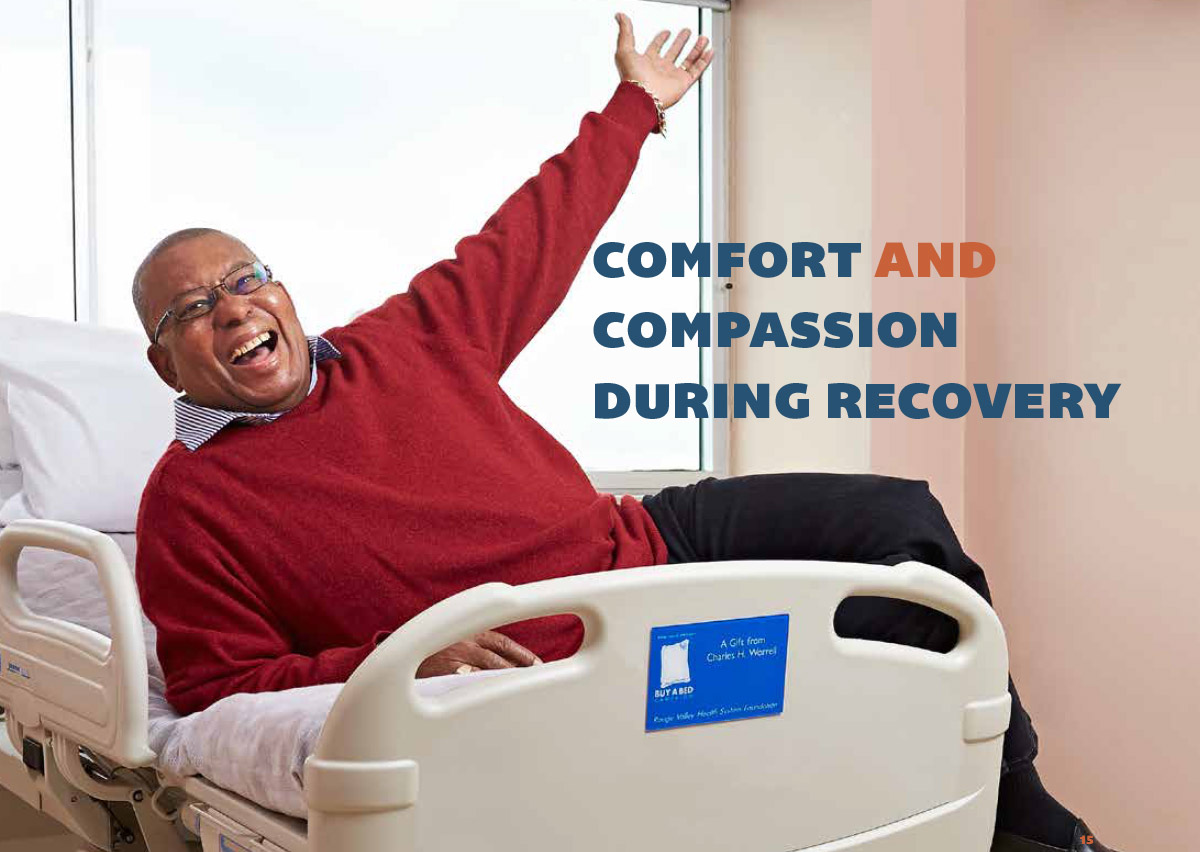 Very happy man raising his arm and laying on a hospital bed